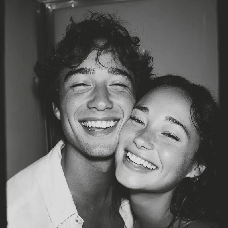 Black and white close-up portrait of a joyful young couple smiling