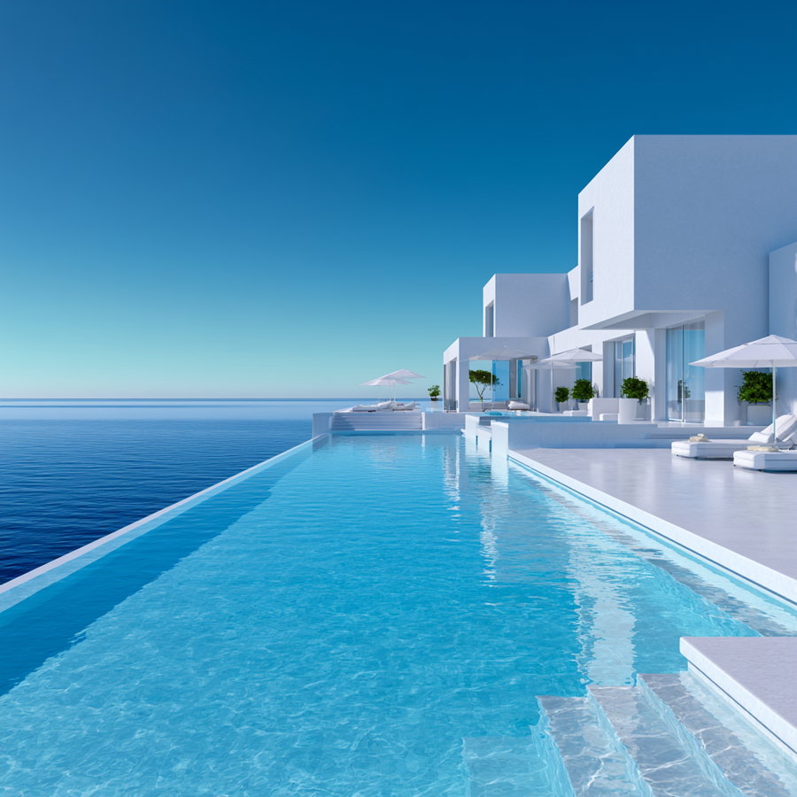 A modern white villa with clean architectural lines features an infinity pool that seamlessly merges with the blue ocean under a clear sky, accompanied by white umbrellas and lounge chairs.