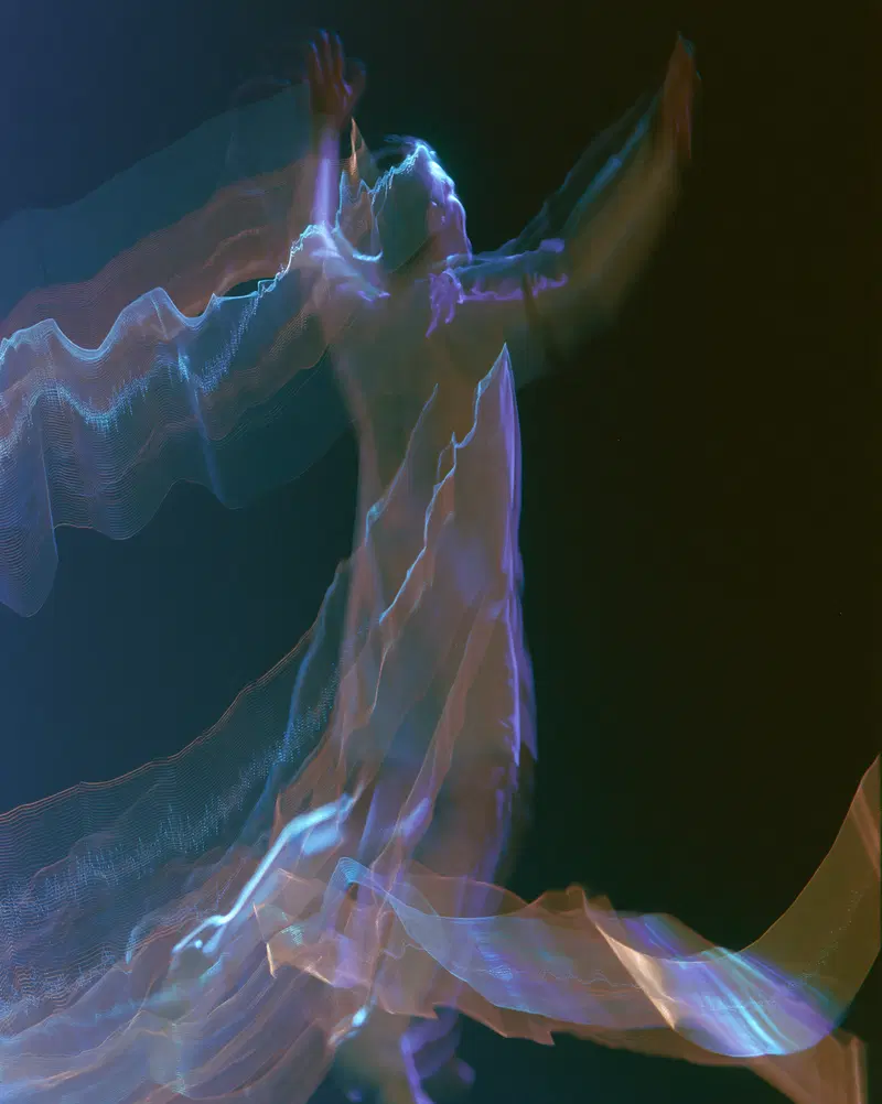 Abstract colorful light trails creating human-like forms in motion