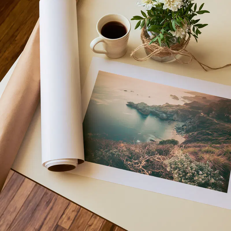 Coastal landscape print with rocky shore and calm water on a desk