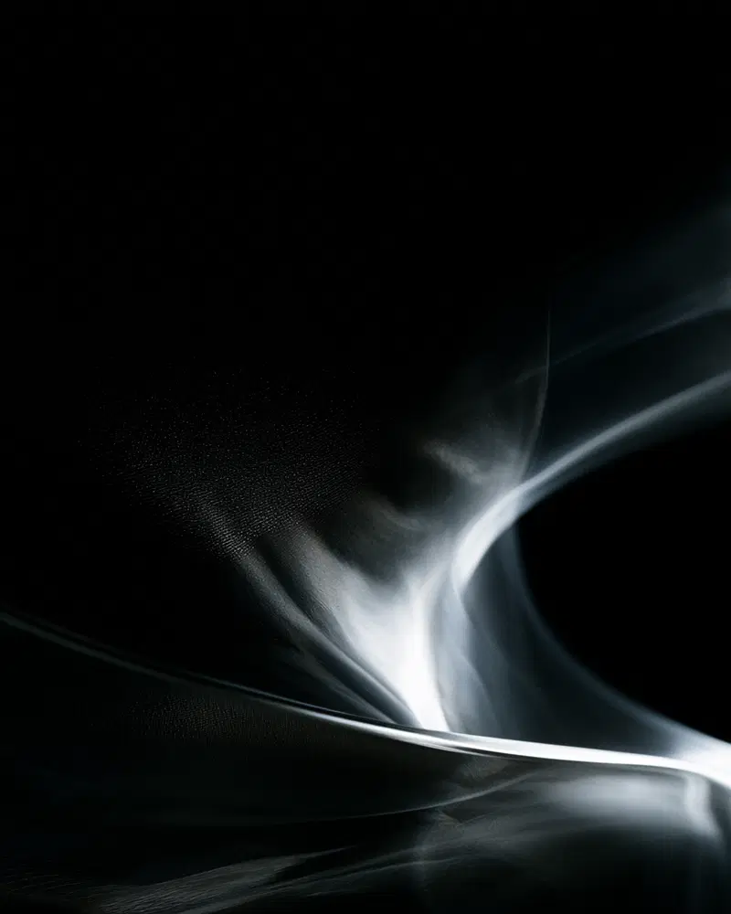 Abstract light and shadow play with fluid, wave-like shapes on black