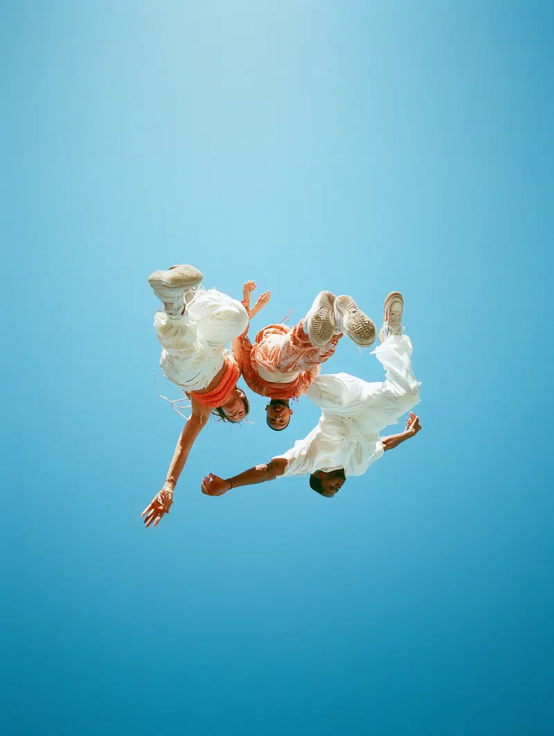 Creative low angle portrait of three people jumping against blue sky