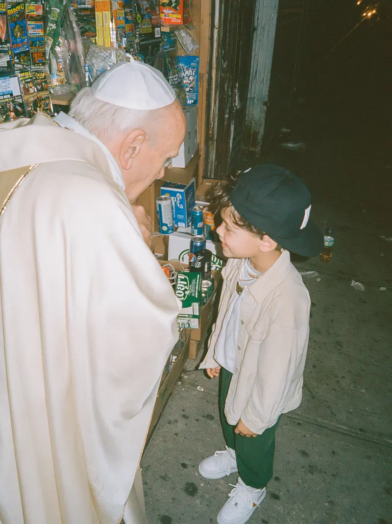 Candid street photography of an elderly man talking to a child at night