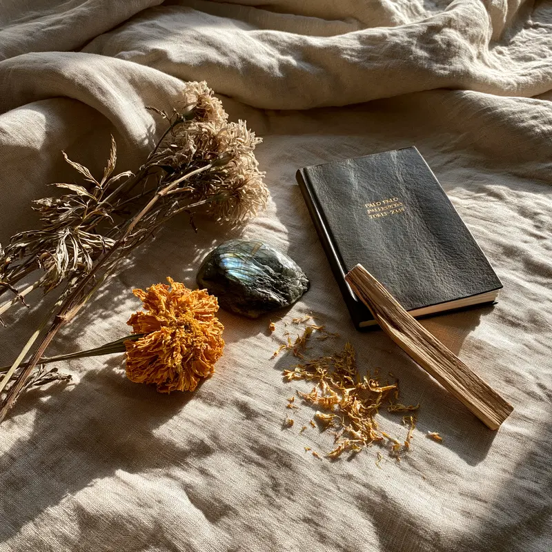 Still life arrangement with dried flowers, stone, book, and wooden stick