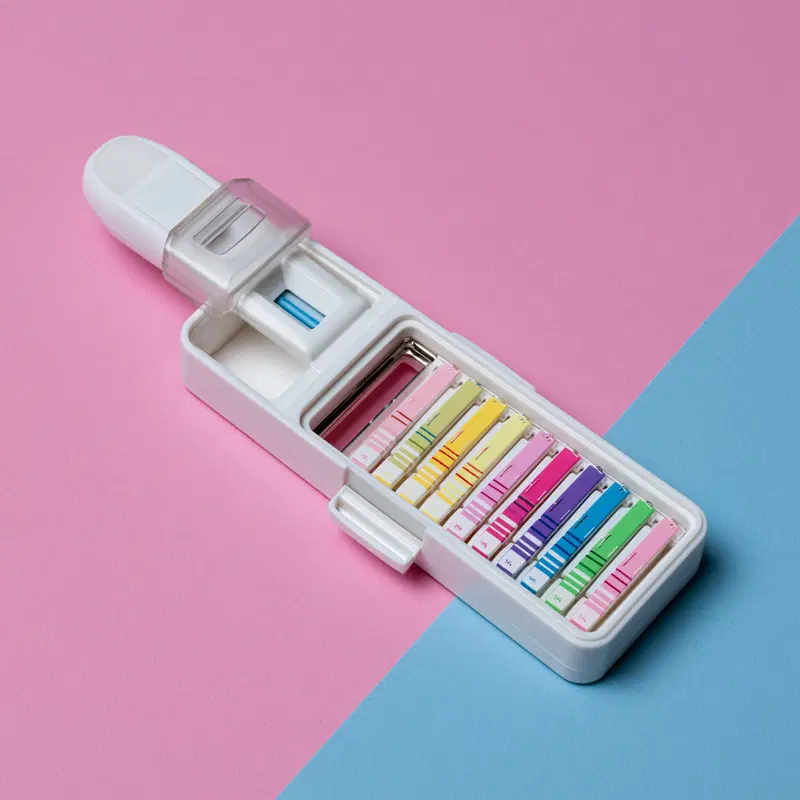 Colorful pregnancy test kits arranged on a pastel pink and blue background
