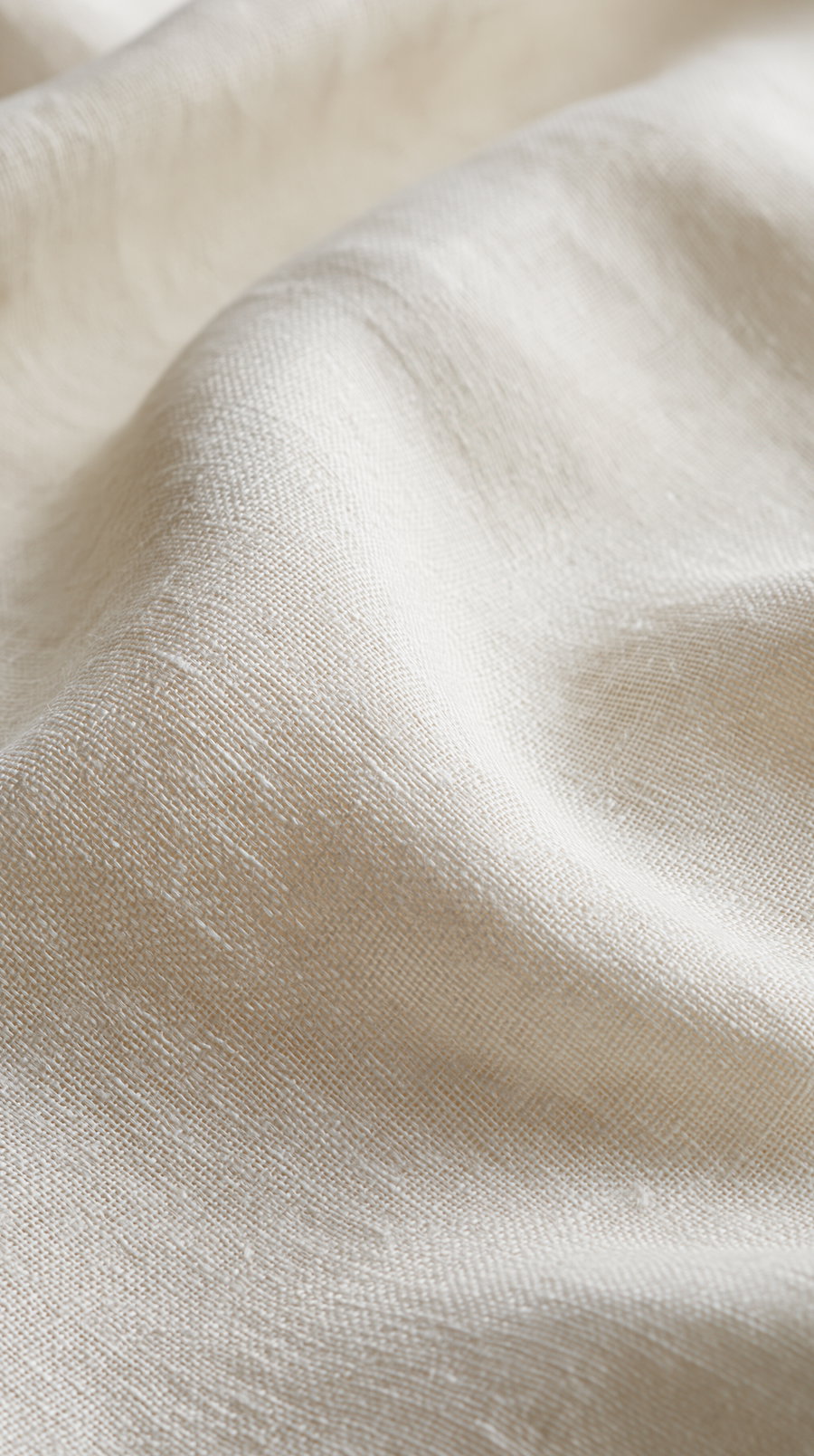 A close-up view of wrinkled light beige linen fabric showing the woven texture and fibers