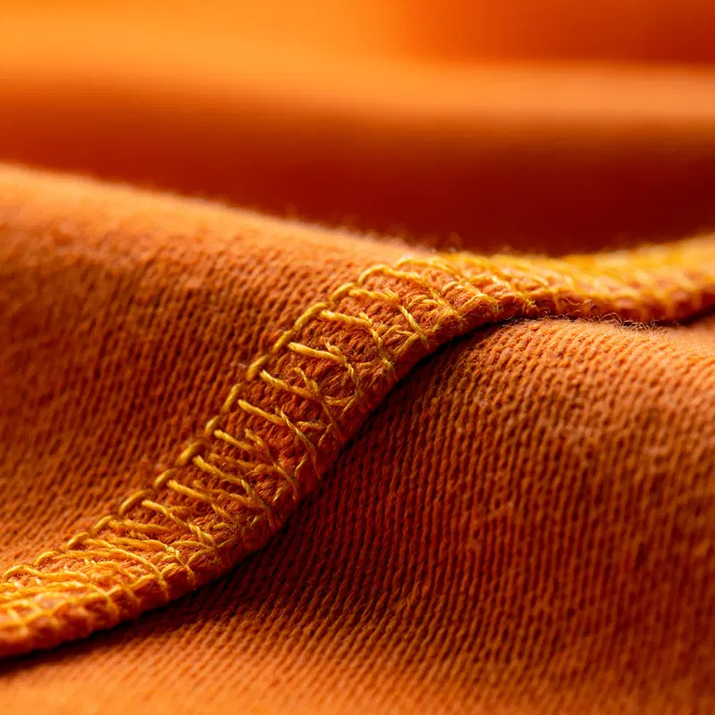 Close-up view of orange fabric texture with detailed stitching