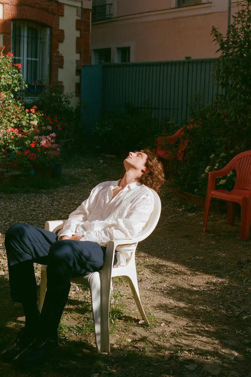 Relaxed young man in white shirt enjoying sunlight outdoors