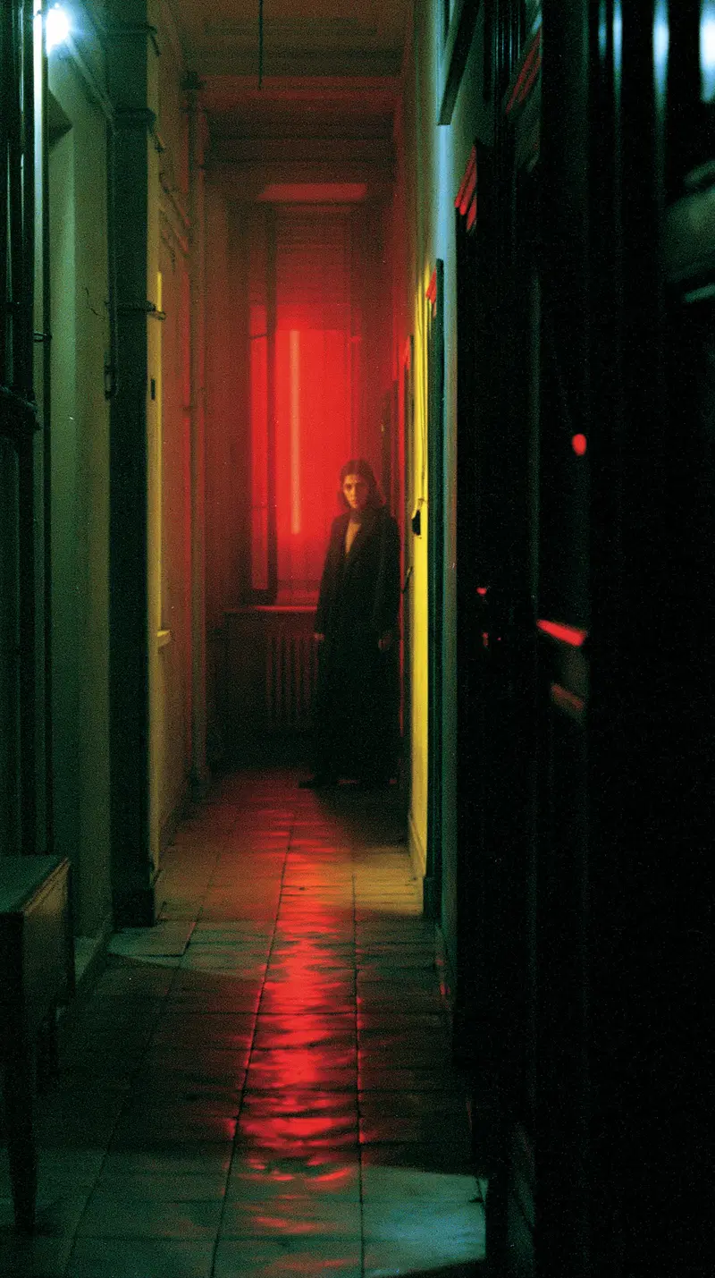 Moody corridor with a person standing near a red illuminated area