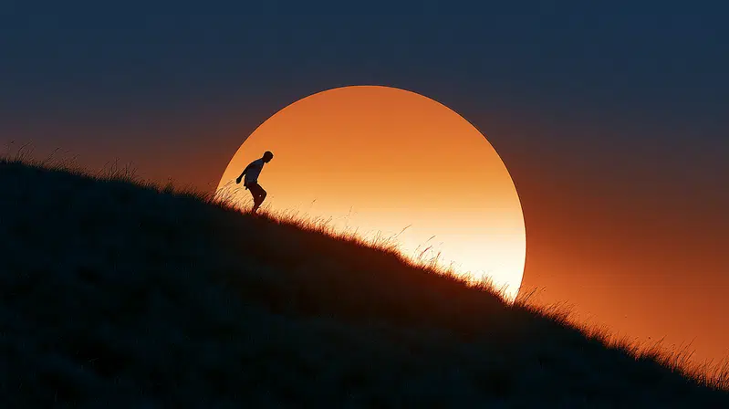 Silhouette of a person walking down a grassy hill with large glowing sunset