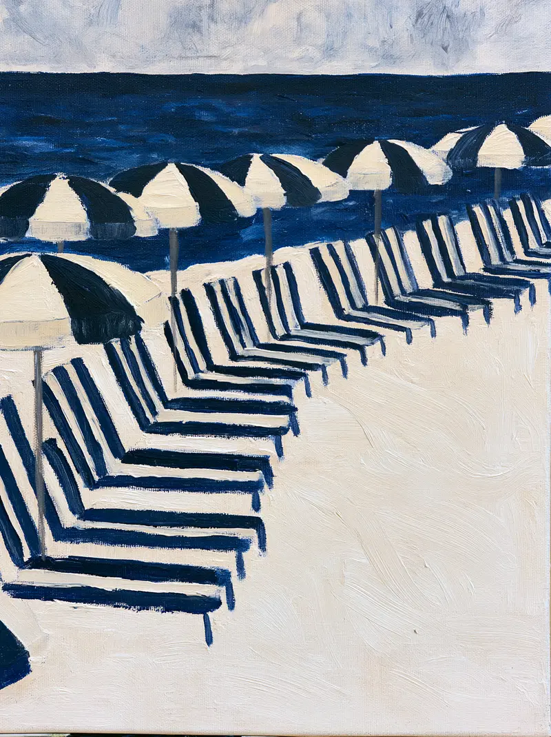 Calm beach scene with rows of black and white umbrellas and chairs