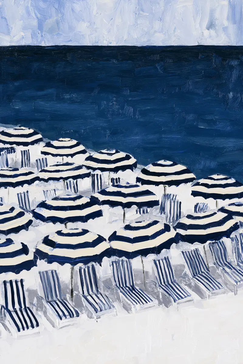 Beach scene with striped umbrellas and lounge chairs by deep blue ocean