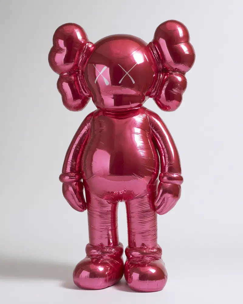 Shiny metallic balloon sculpture of a cartoon-like figure with crossed eyes