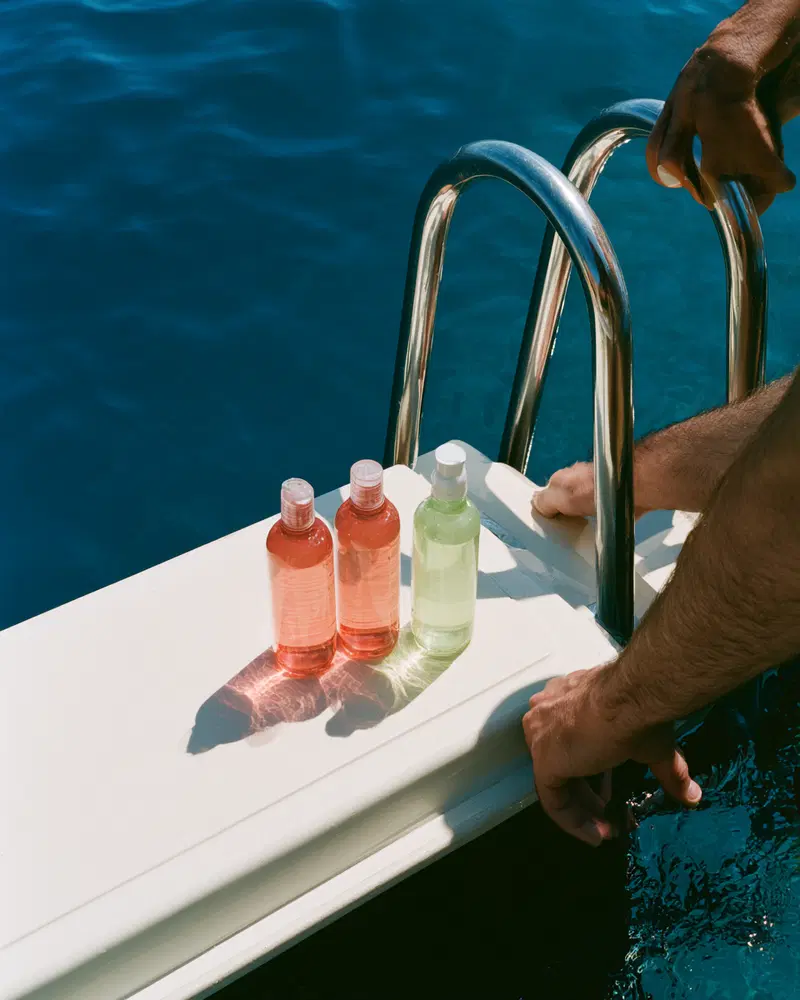 Bottles with liquids placed on a boat ladder platform over sea water