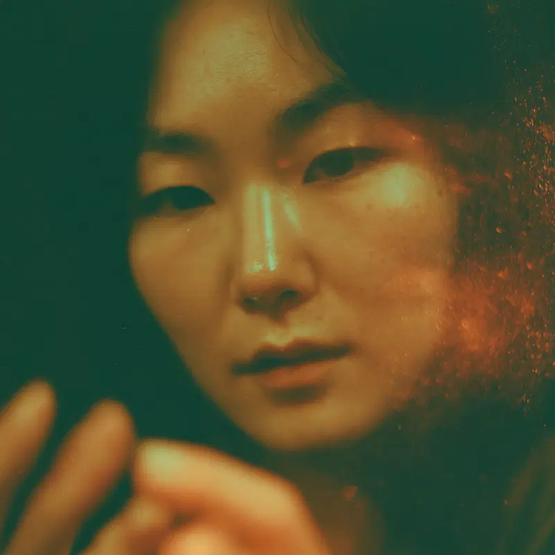 Close-up portrait of a thoughtful woman with a soft green and orange light