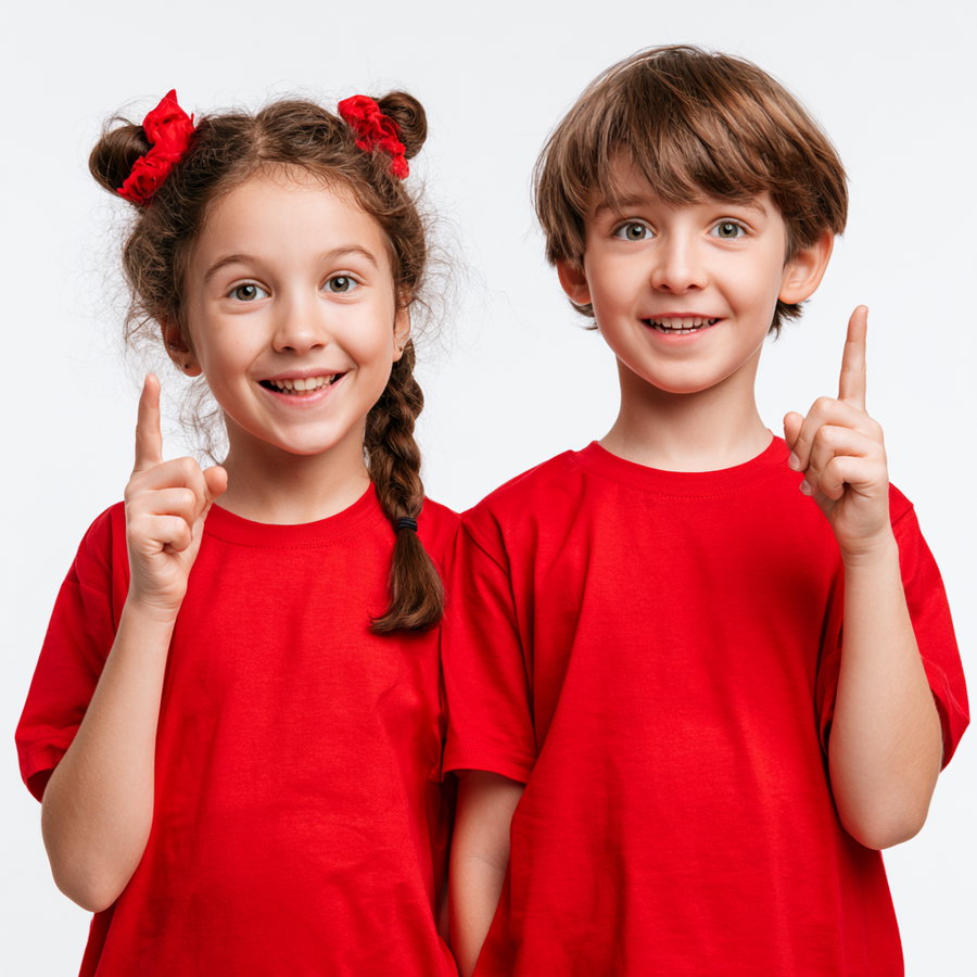 Portrait of a smiling young girl and boy wearing matching red shirts, each raising one finger and looking forward against a plain white background