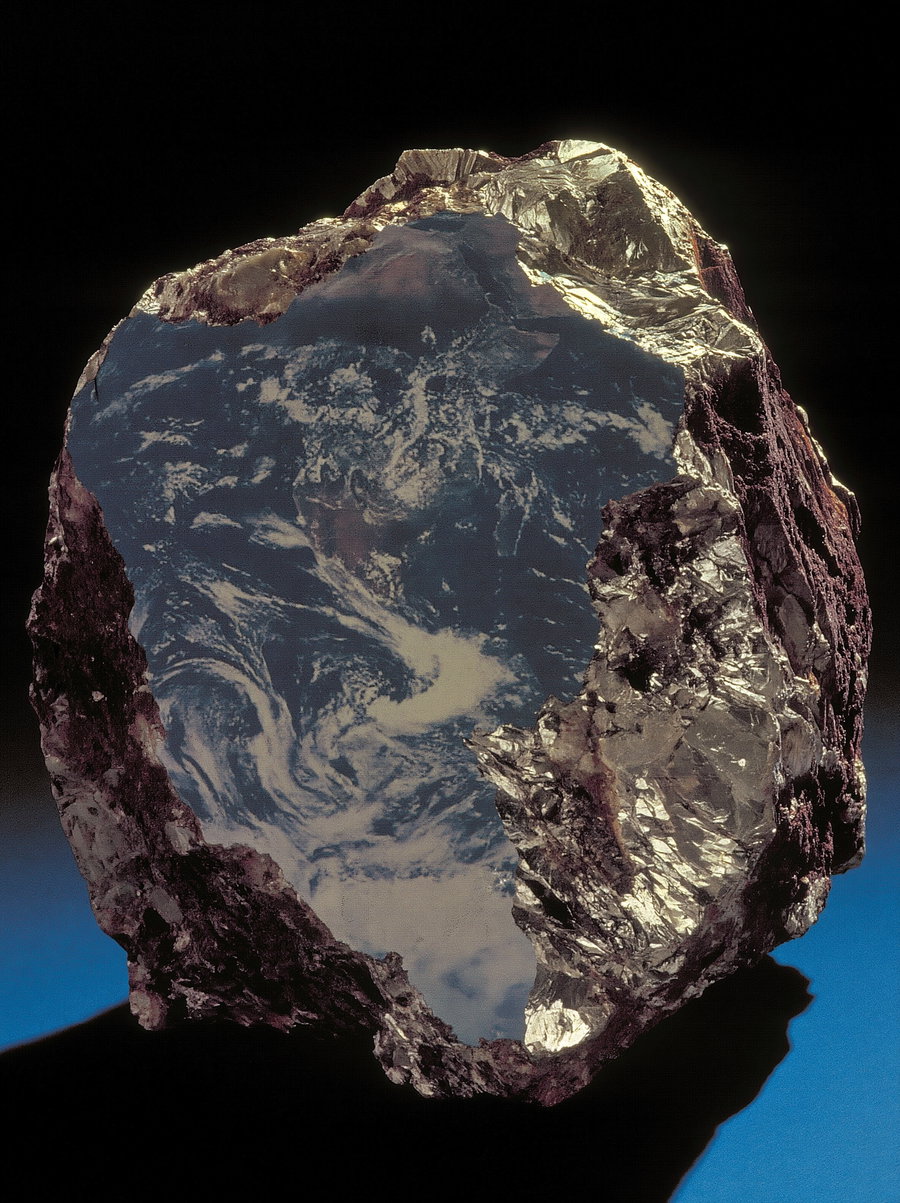 A rock with a reflective surface displaying a cloudy earth view