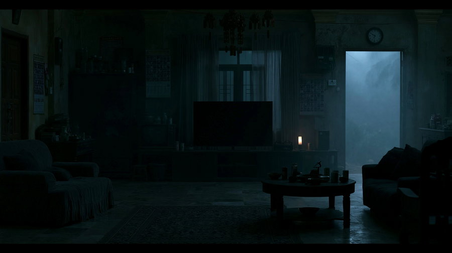 An interior of a living room featuring a sofa, coffee table, and a television, with shadows and fog creating an eerie ambiance.