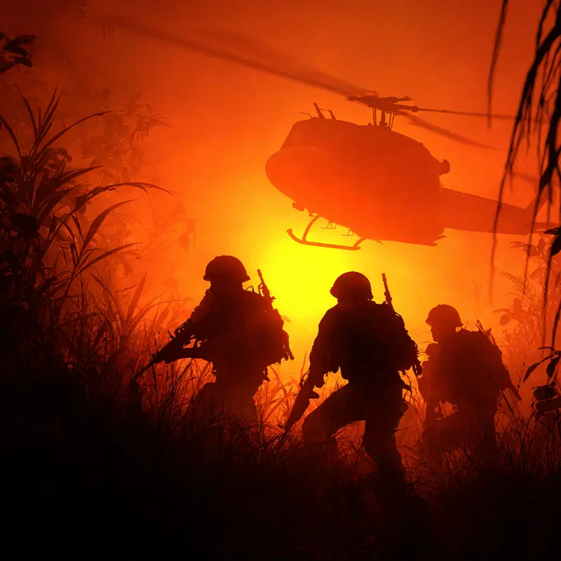 Epic scene of soldiers advancing through a dense jungle with a helicopter flying overhead