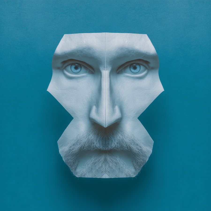 A blue-toned abstract sculptural portrait of a man's face with intense blue eyes, prominent nose, and detailed beard on a plain blue background.