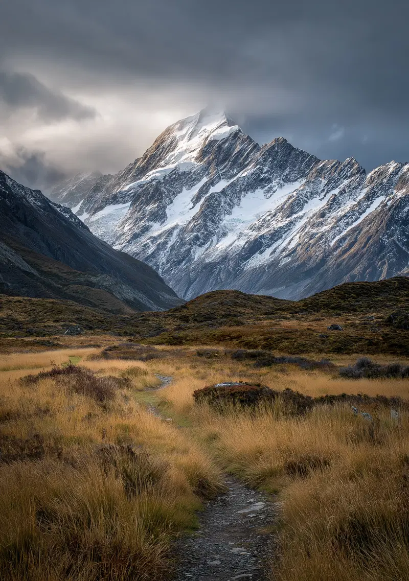Scenic mountain landscape with snowy peaks under moody cloudy sky